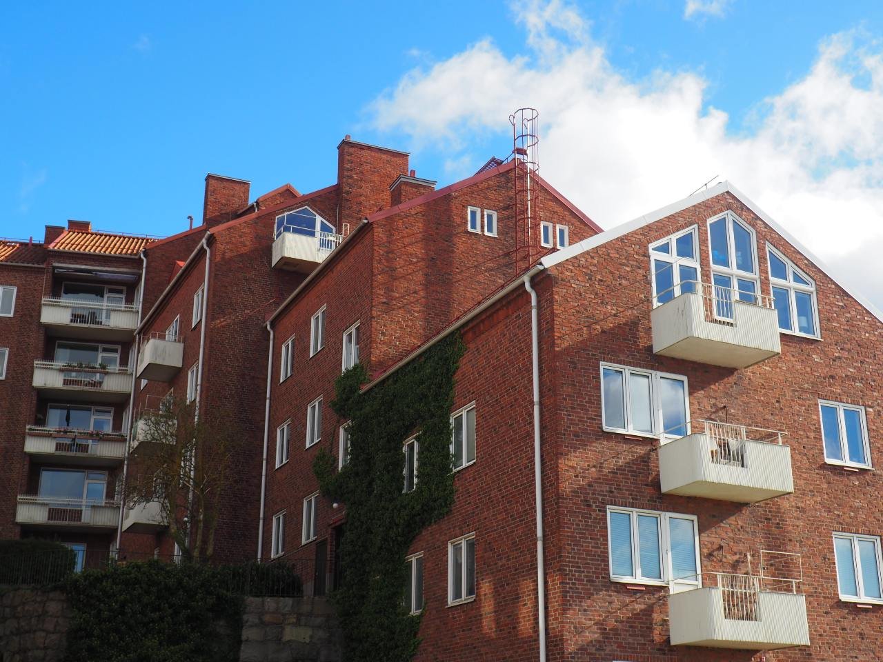 Brick apartment buildings with balconies under a blue sky