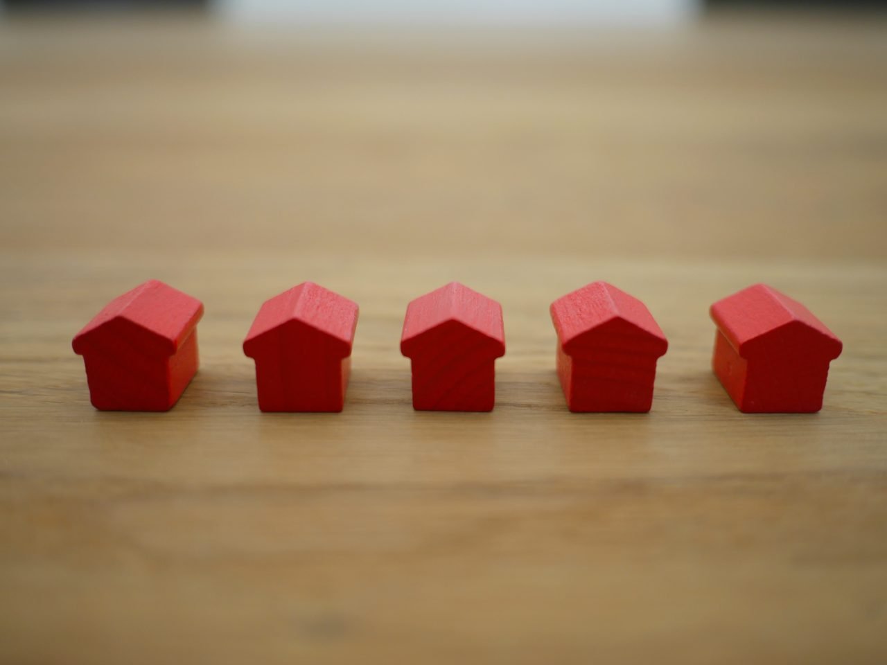 Miniature houses. Five small red model houses in a row