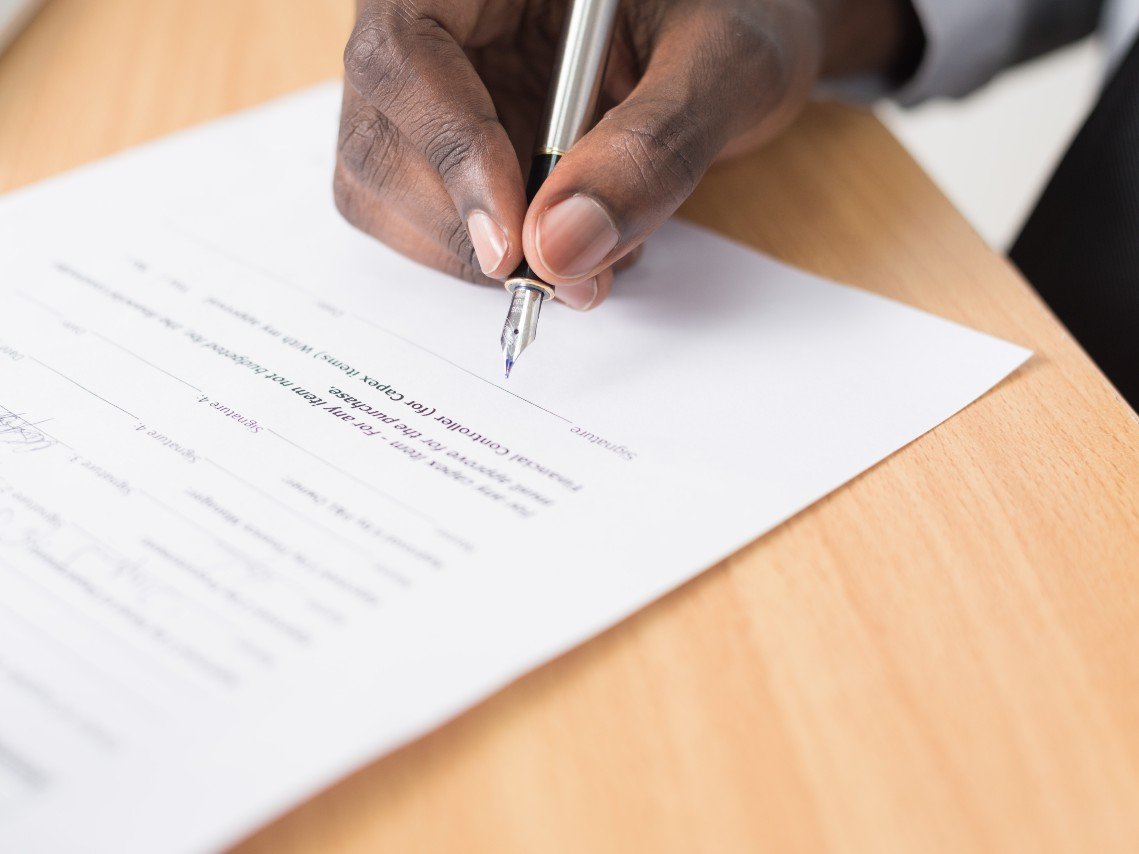 Close-up of a borrower signing loan paperwork
