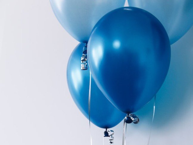 Blue balloons against a pale wall