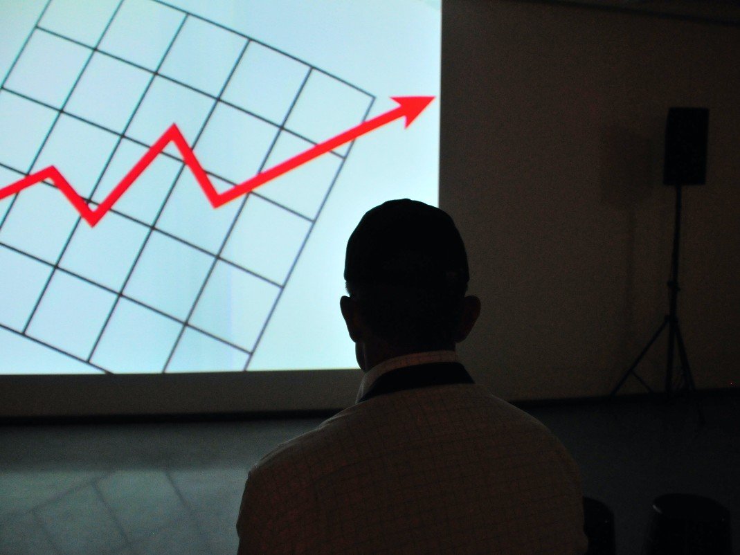 A person watching a projected line chart trending upward