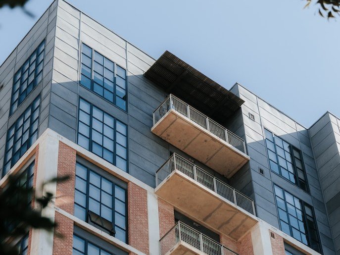 Two-tone apartment building with a blue sky. A modern apartment building with cantilevered balconies