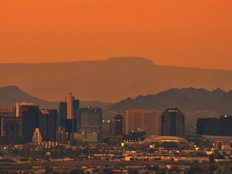 The Phoenix skyline at sunset with mountains behind it