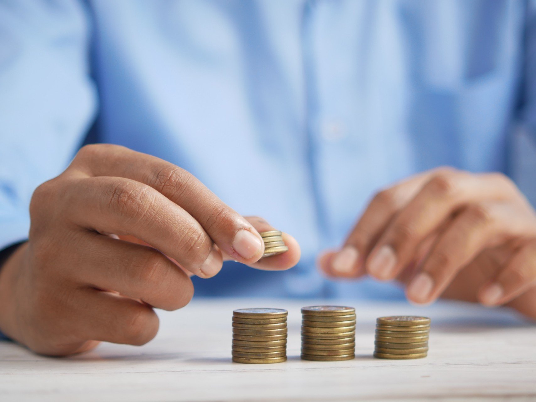 (Image) A person stacking coins into descending piles