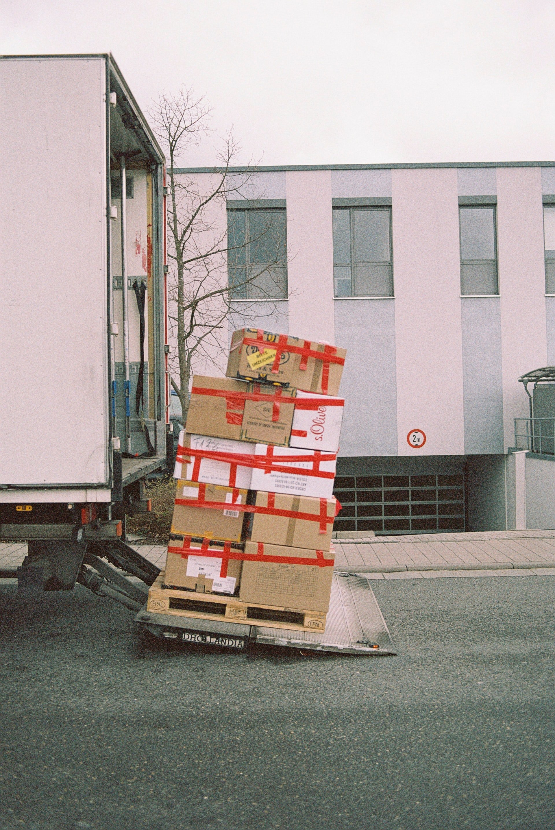Moving boxes stacked on a hand truck at the back of a moving truck