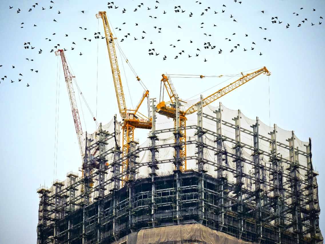 Tower cranes and scaffolding on a high-rise apartment construction site