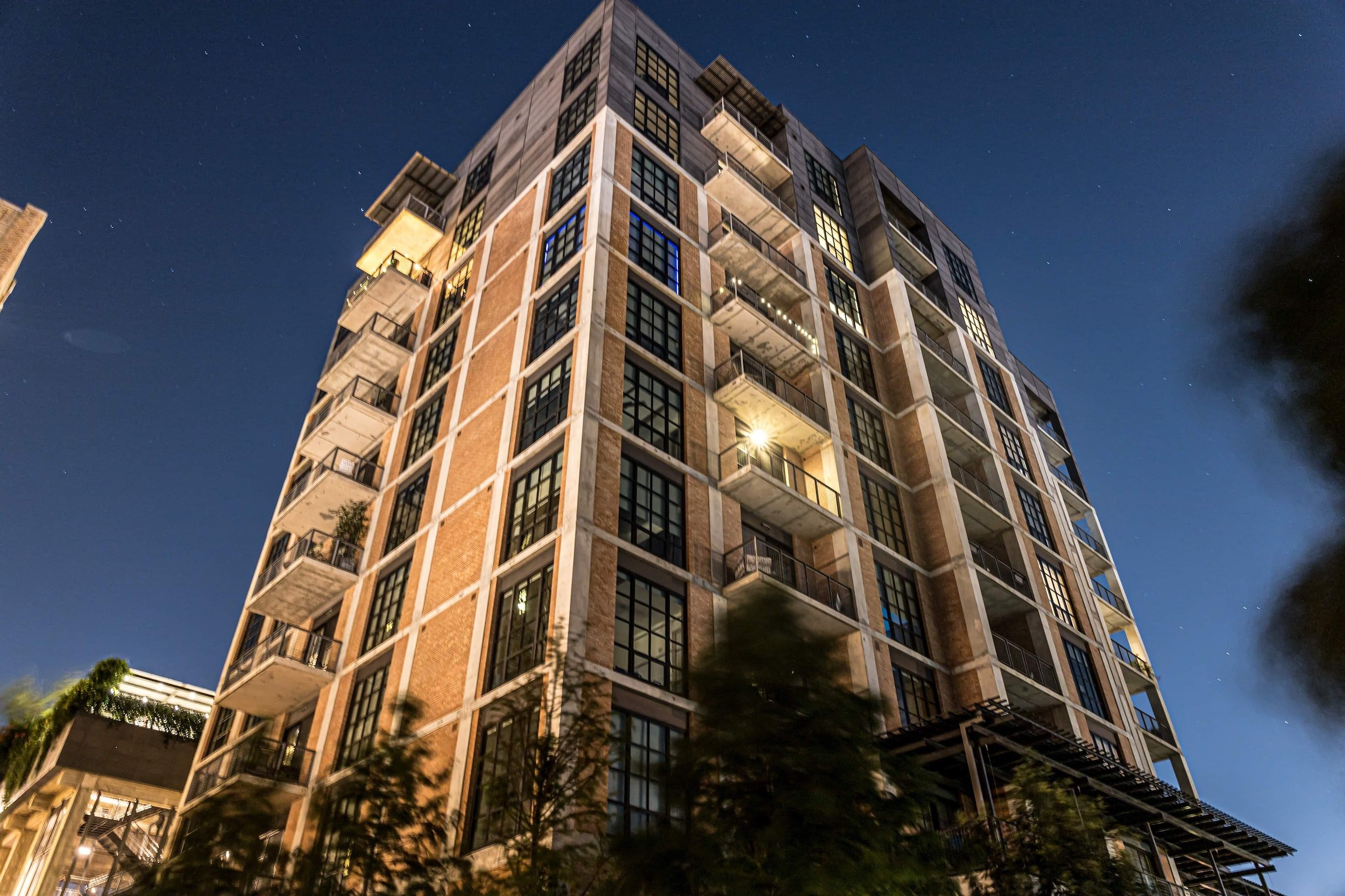 A mid-rise apartment building lit up at dusk