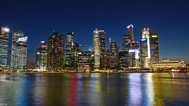 An illuminated city skyline at night reflected in the water