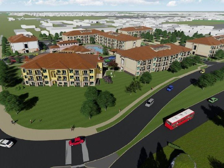 Rendering of several three-story multifamily buildings surrounding by grass and trees with rendered vehicles driving by on a nearby road. Legacy Riverside, an affordable housing community developed by RISE Residential